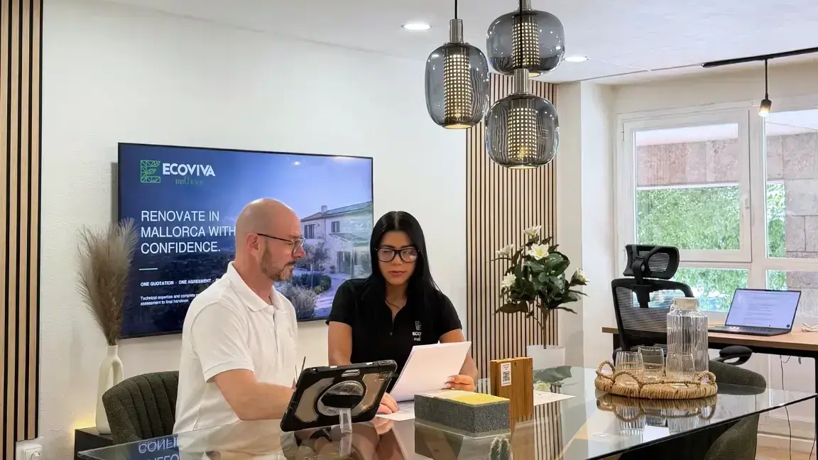 Markus and Maritza discussing renovation plans and technical materials in the EcoViva Offices & Studio